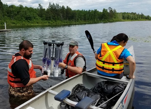 Scientists deploying a device to collect pore-water samples from different depths in lake sediments.